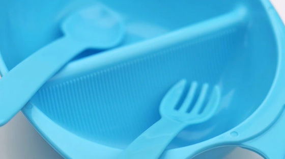 Plástico acima da bacia do bebê de 3 meses com forquilha da colher